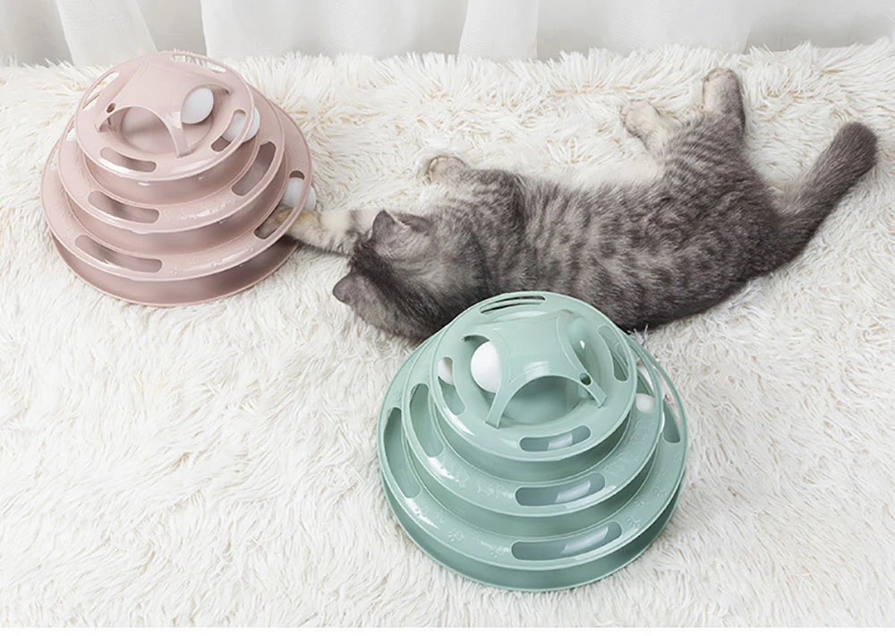 Gato jugando con la torre de juguete de cuatro niveles
