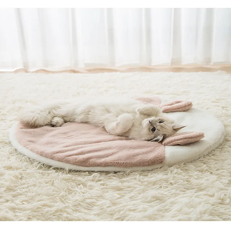 Un gato acostado boca arriba sobre una cama circular para mascotas. El gato parece relajado y cómodo, con las patas estiradas y el vientre expuesto.