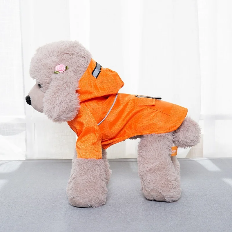 Un perro de peluche blanco con un impermeable naranja