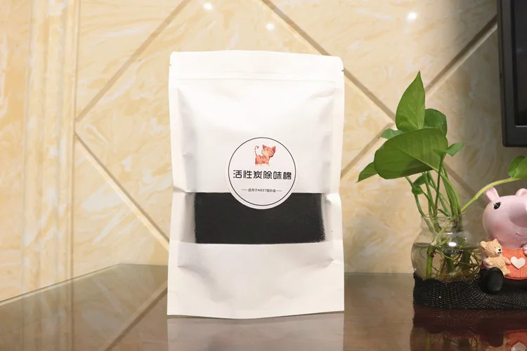 Una bolsa de granos de café se sienta en una mesa al lado de una planta en maceta