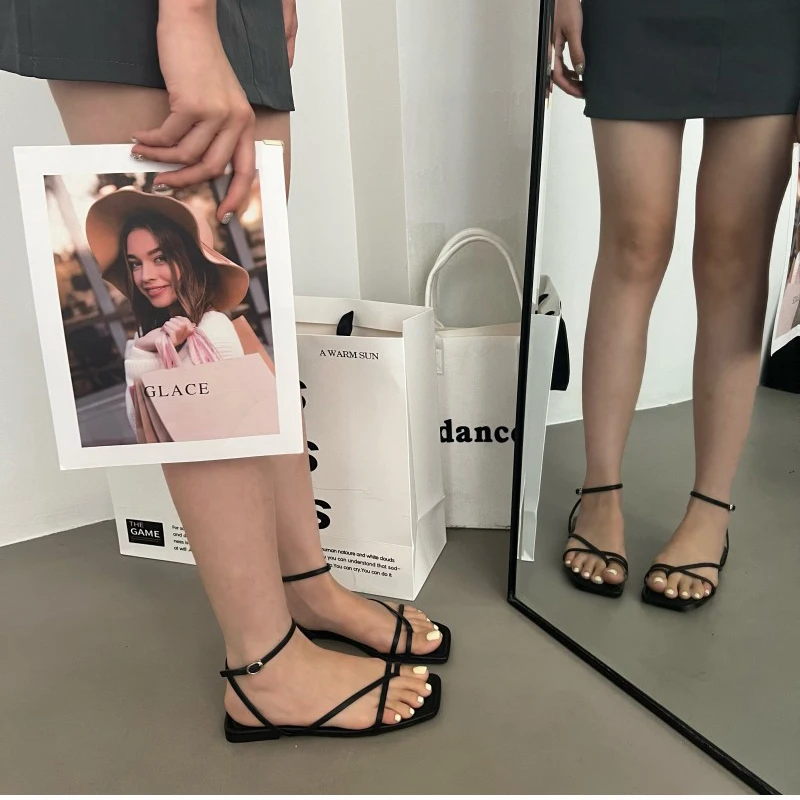 Sandalias combinadas con vestido veraniego en paseo urbano