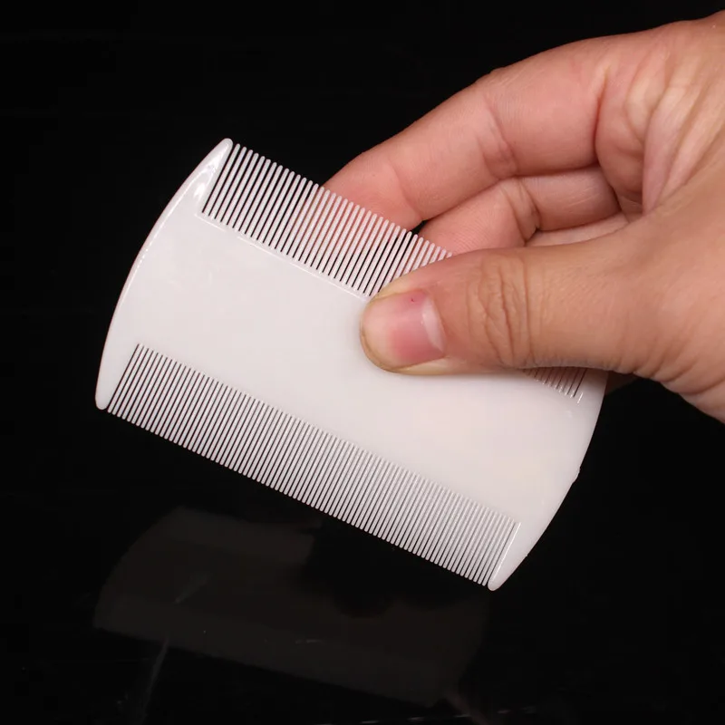 Peine pequeño de doble cara mostrado en la palma de la mano