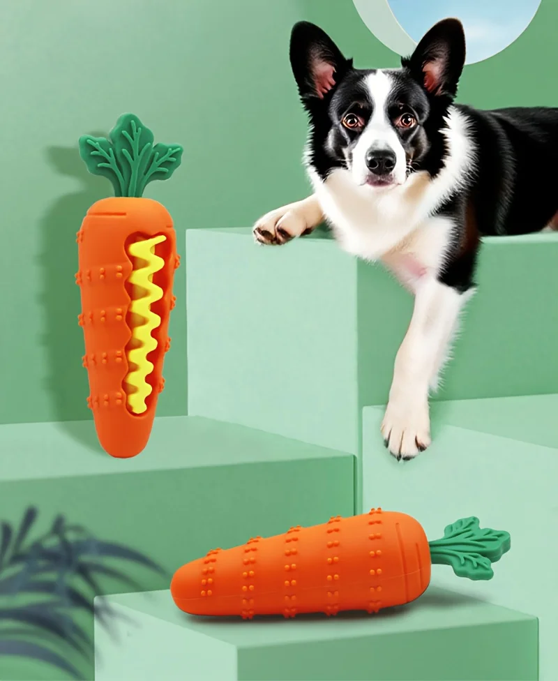Cachorro mordiendo el juguete chirriante de zanahoria