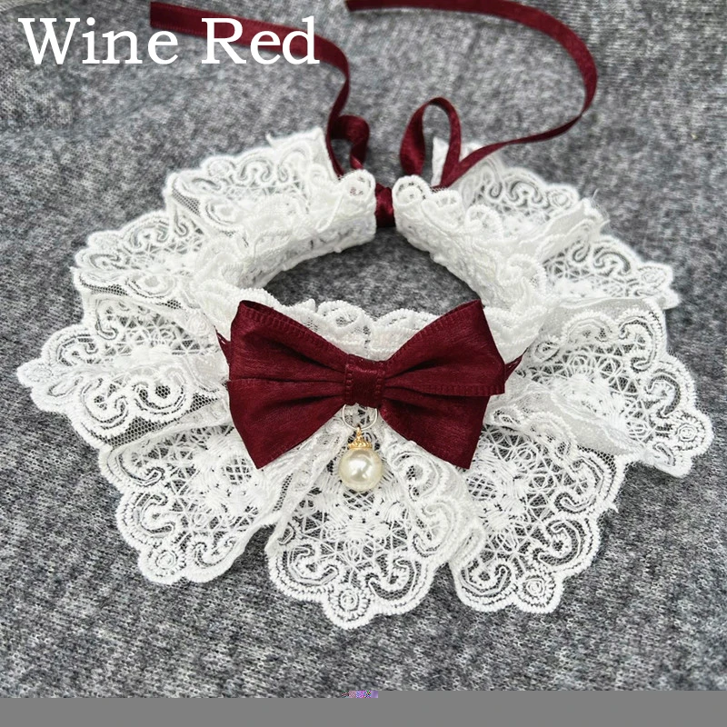 Perro pequeño llevando collar de perlas con lazo