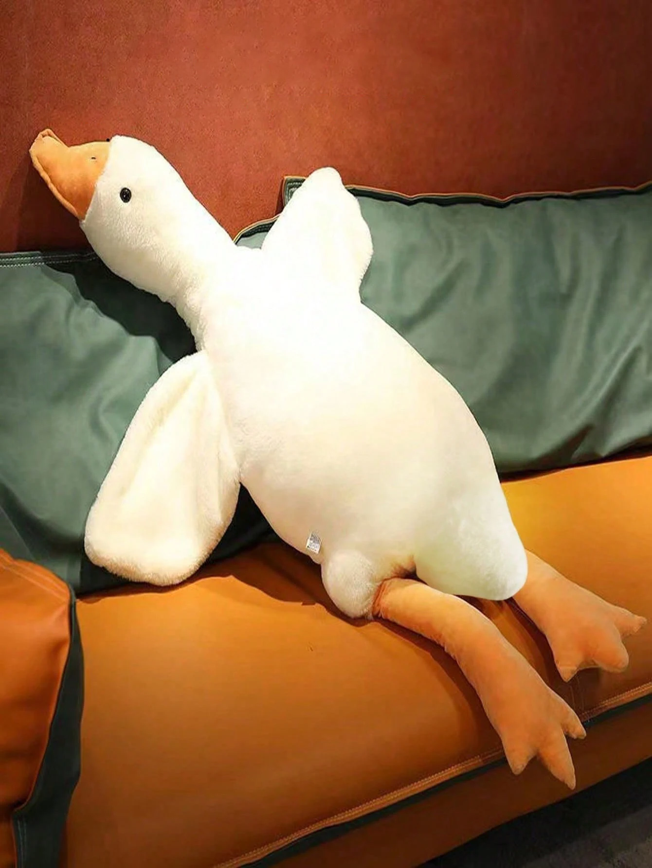 Un pato relleno está acostado en un sofá