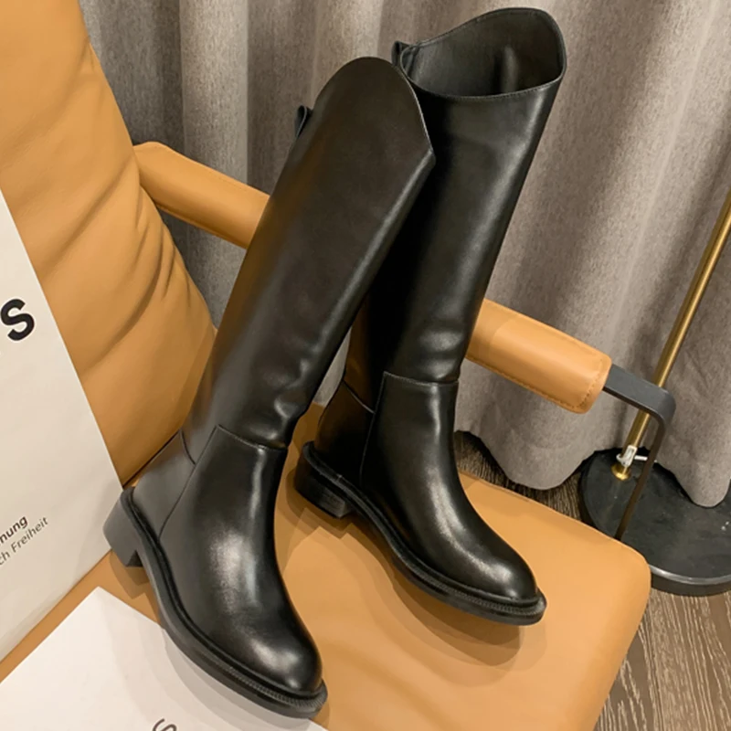 Un par de botas negras sentadas en una silla