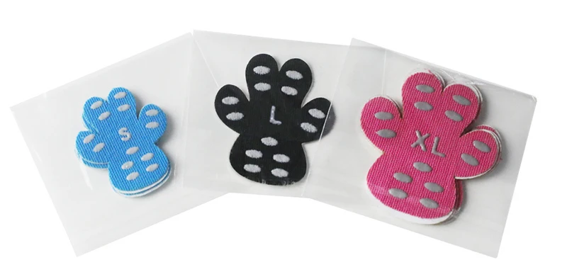 Mano aplicando un parche desechable en la pata de un perro