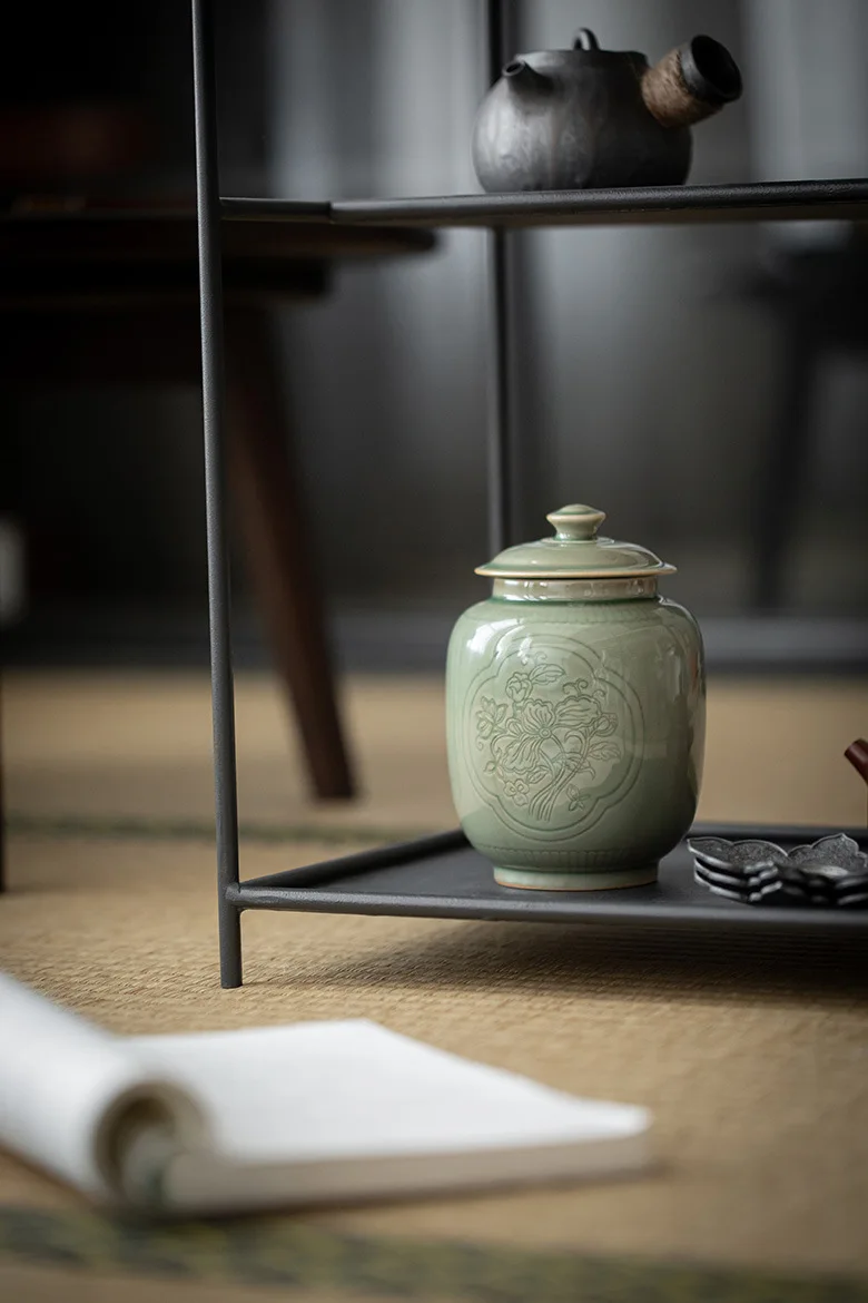 Escena de repisa con urna, planta suculenta y marco de foto en ambiente interior