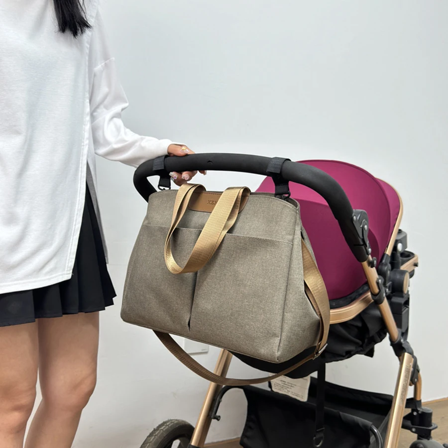 Vista frontal de la bolsa de maternidad con bolsillos externos y asas ajustables