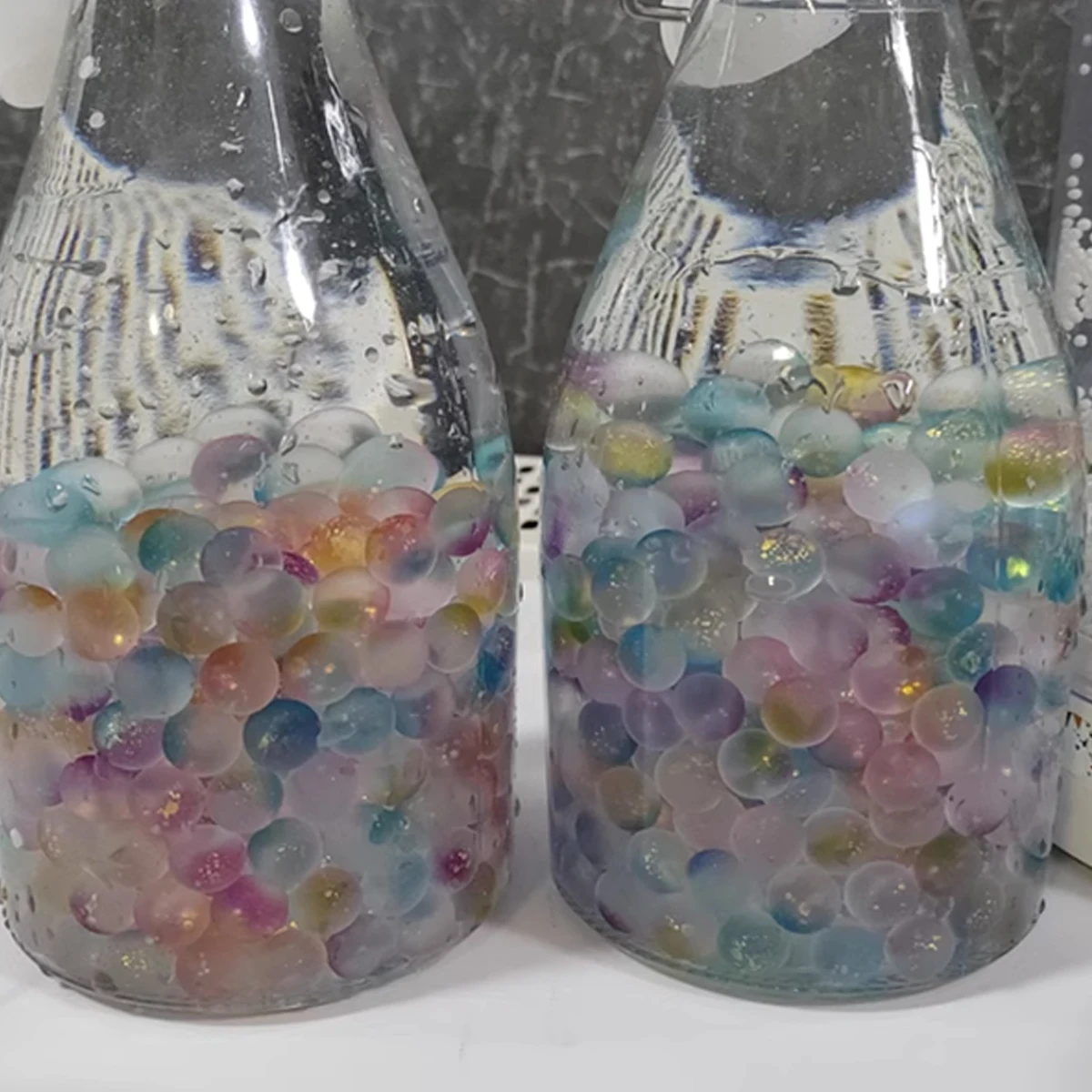 Cuentas de vidrio esmerilado multicolor distribuidas en el fondo de un acuario