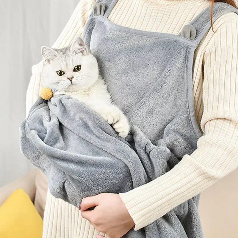 Delantal puesto sobre abrigo mostrando a un gato dentro del bolsillo