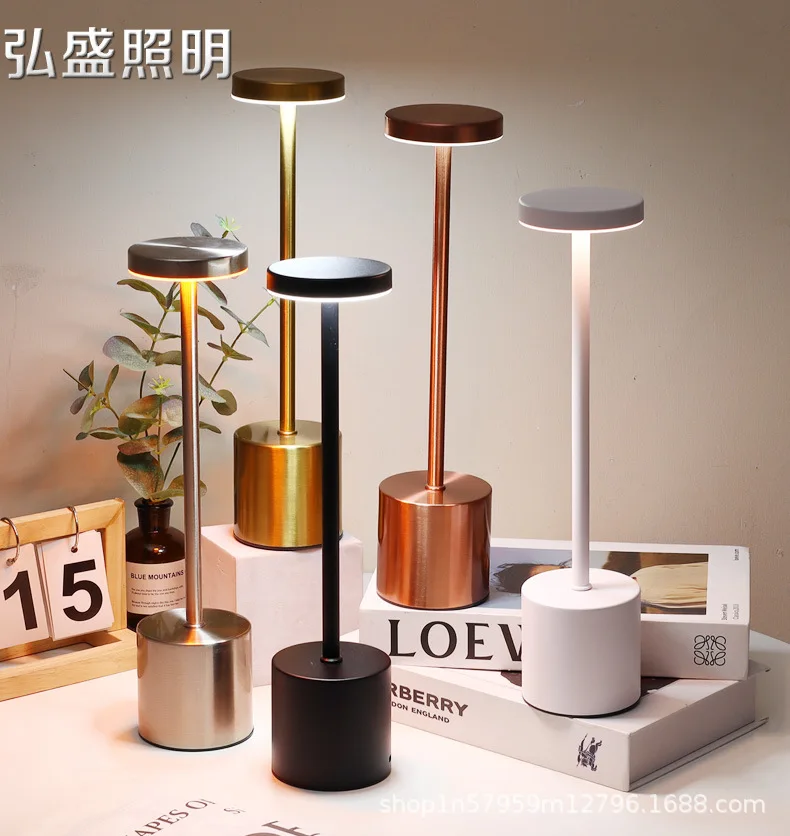 Lámpara de mesa en forma de H encendida sobre una mesa