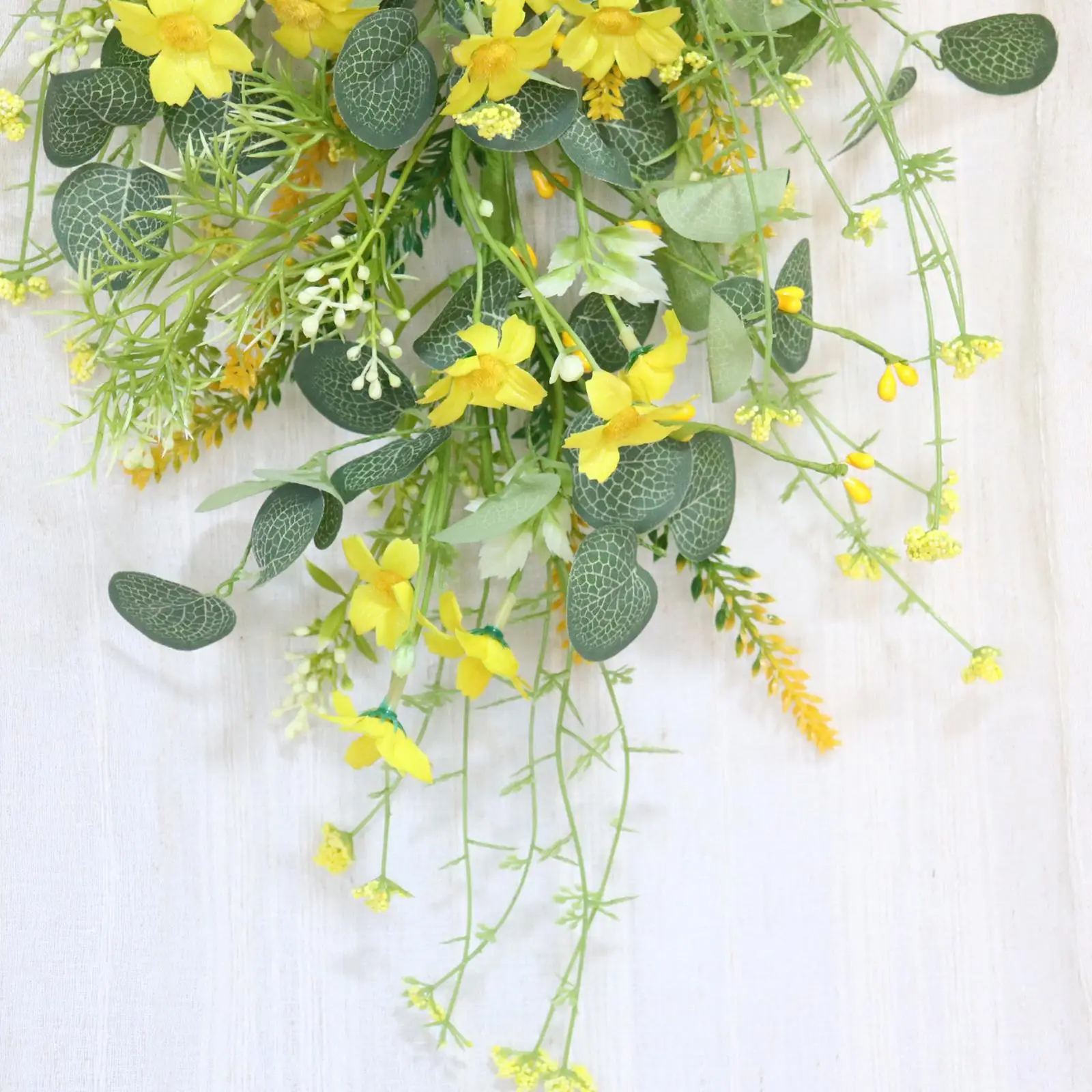 Guirnalda decorativa con lazo y hojas artificiales en tonos verdes y amarillos