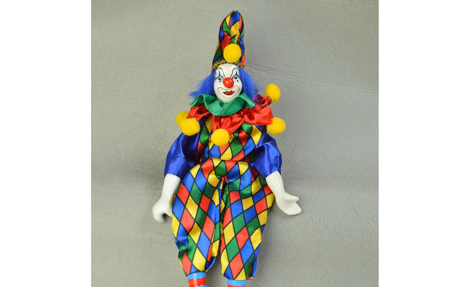 Muñeco de payaso de cerámica sentado con piernas colgantes