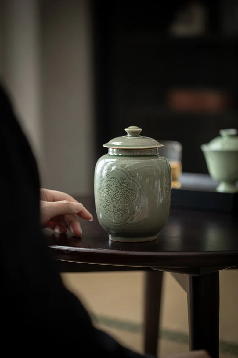 Bolsa de terciopelo gris con cordón y tarjeta de papel kraft alongside the urn