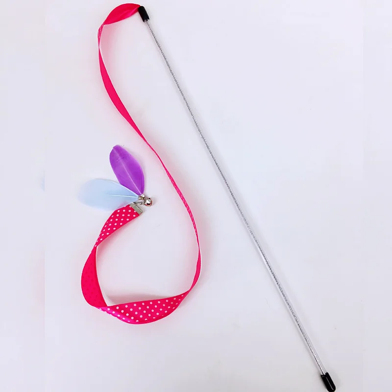 Juguete para gatos en uso, mostrando plumas y cinta de arcoíris