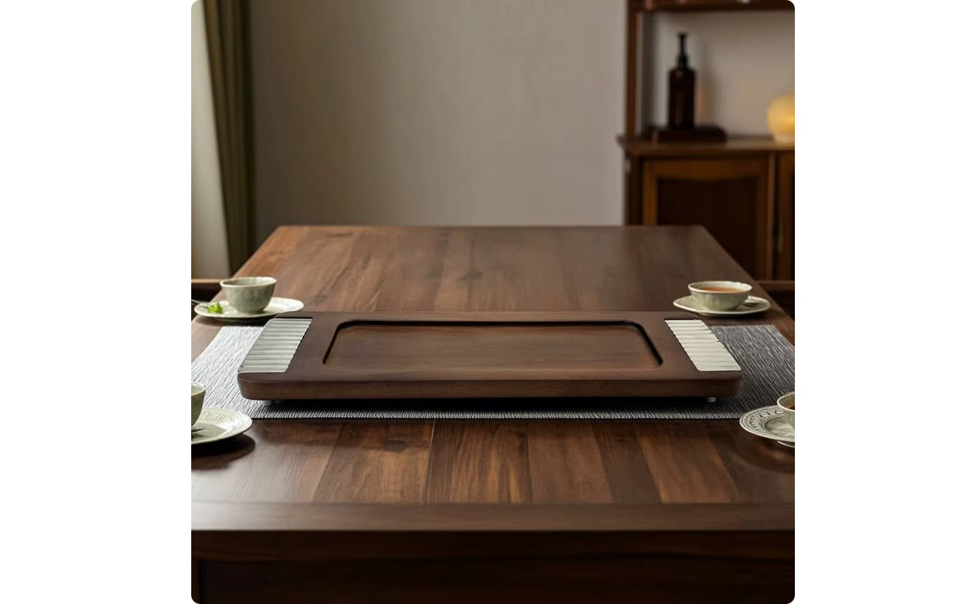 Bandeja decorativa rectangular con patas colocada sobre superficie de madera