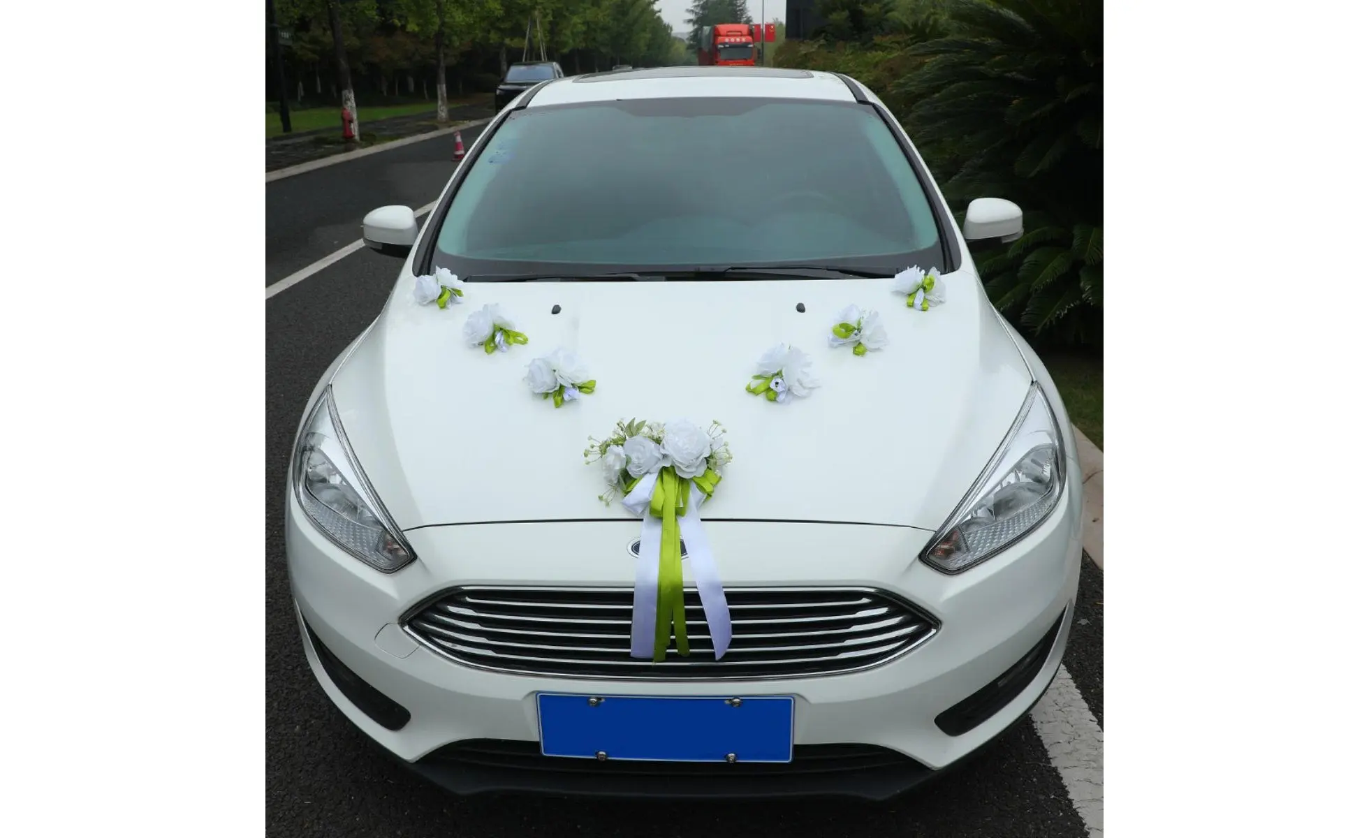 Decoración de coche de boda con flores blancas y verdes