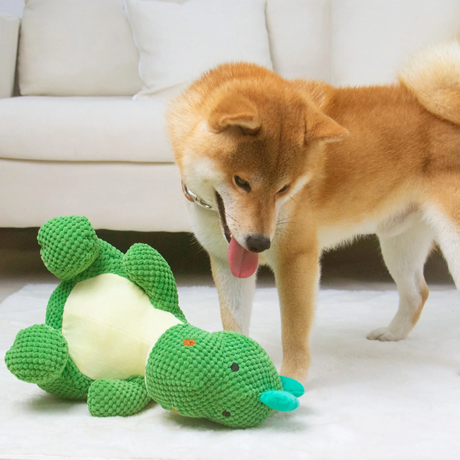 Juguete de dinosaurio siendo mordido por un cachorro