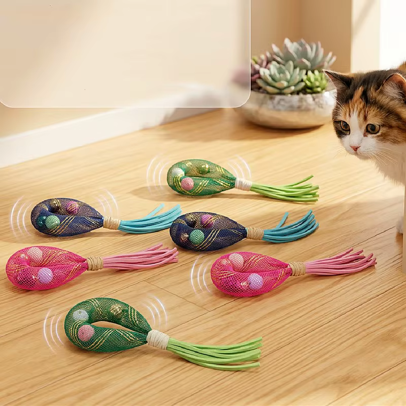Gato jugando con juguete de borlas