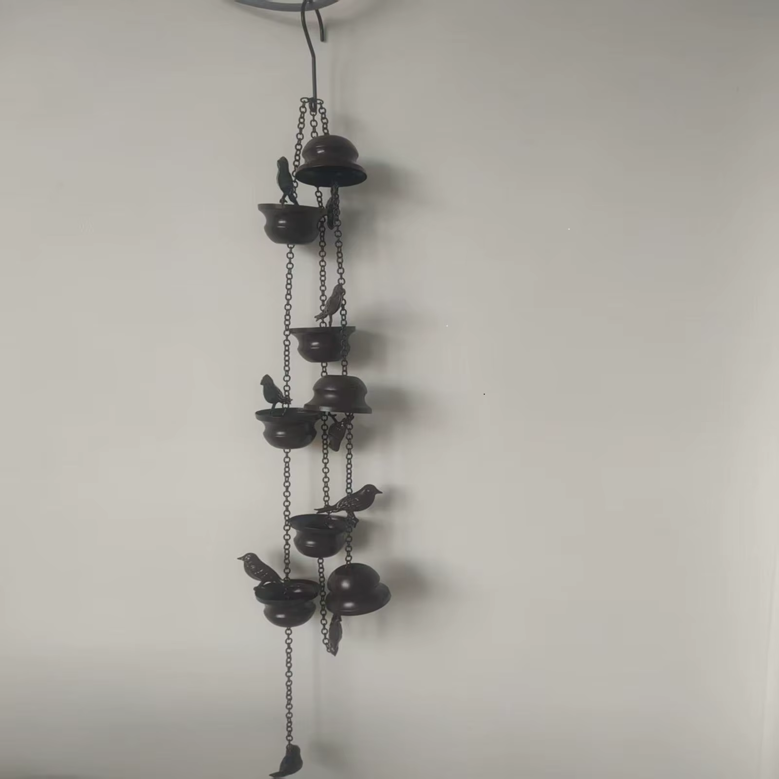 Detalle de las ocho copas con forma de pájaro en la cadena