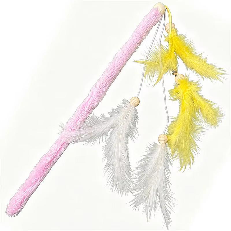 Gato persiguiendo el juguete de caña con plumas y mango de felpa