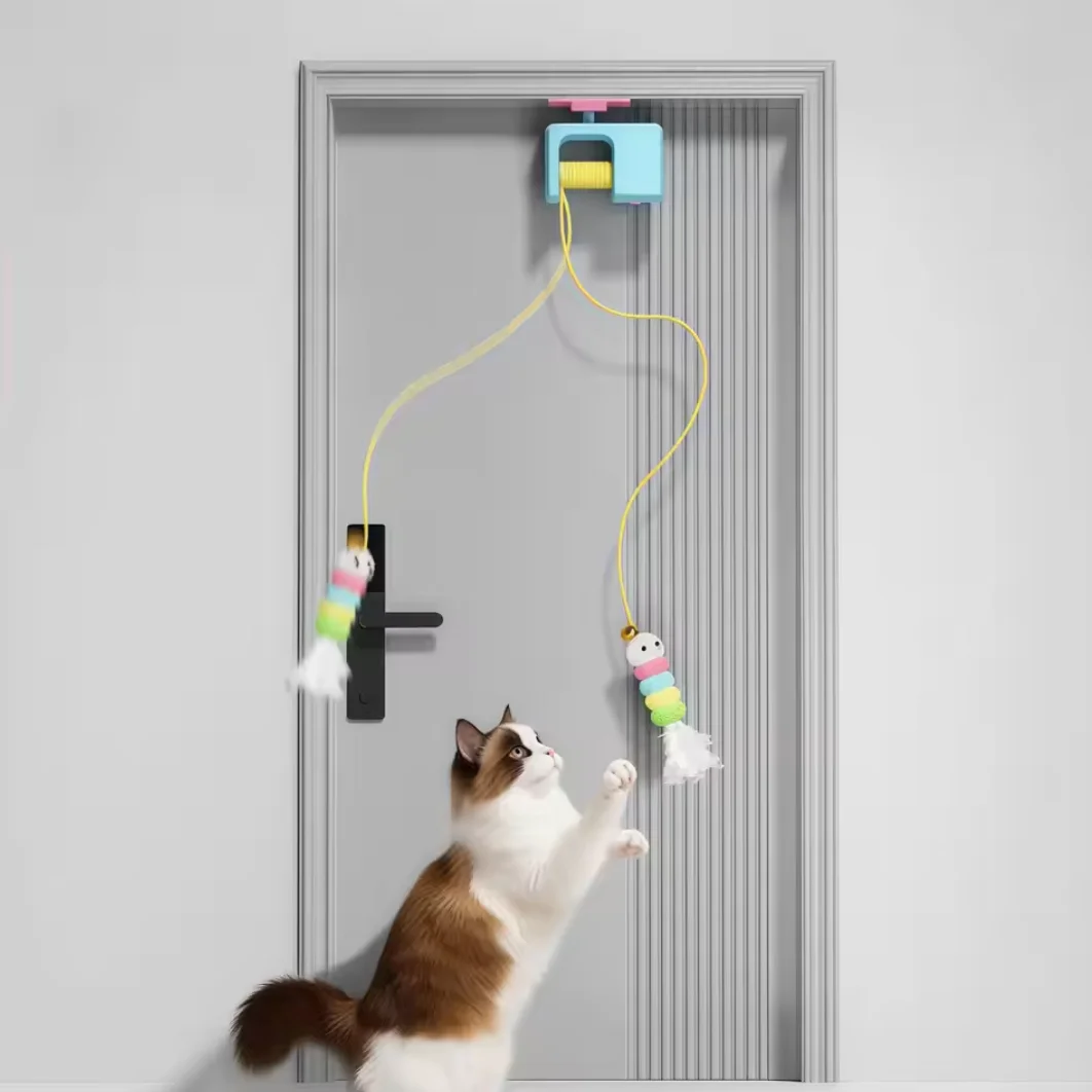 Gato interactuando con ave mecánica colgante en puerta