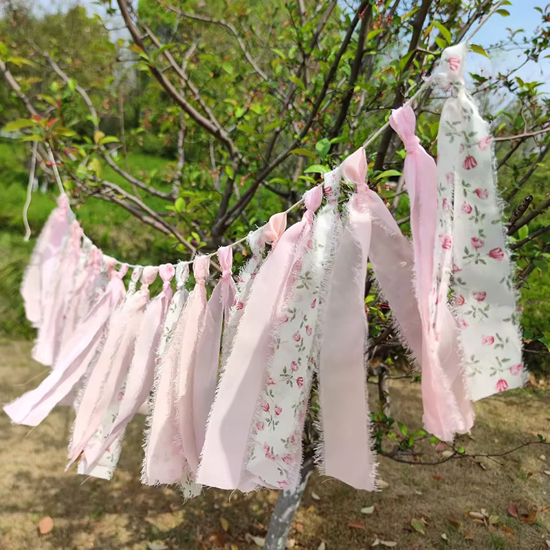 Cinta rosa y borlas que adornan la pancarta