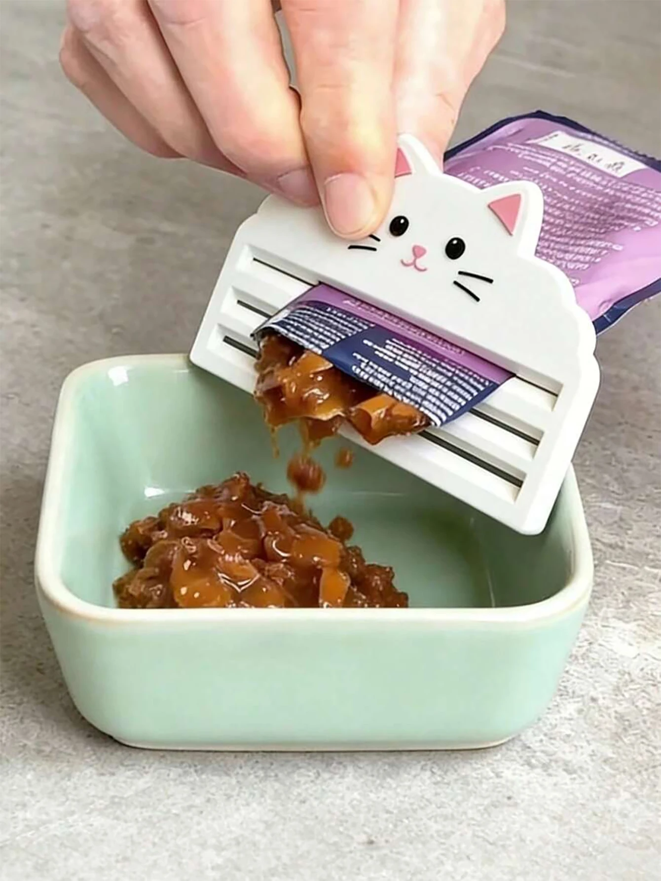 Exprimidor de comida para gatos en uso diario