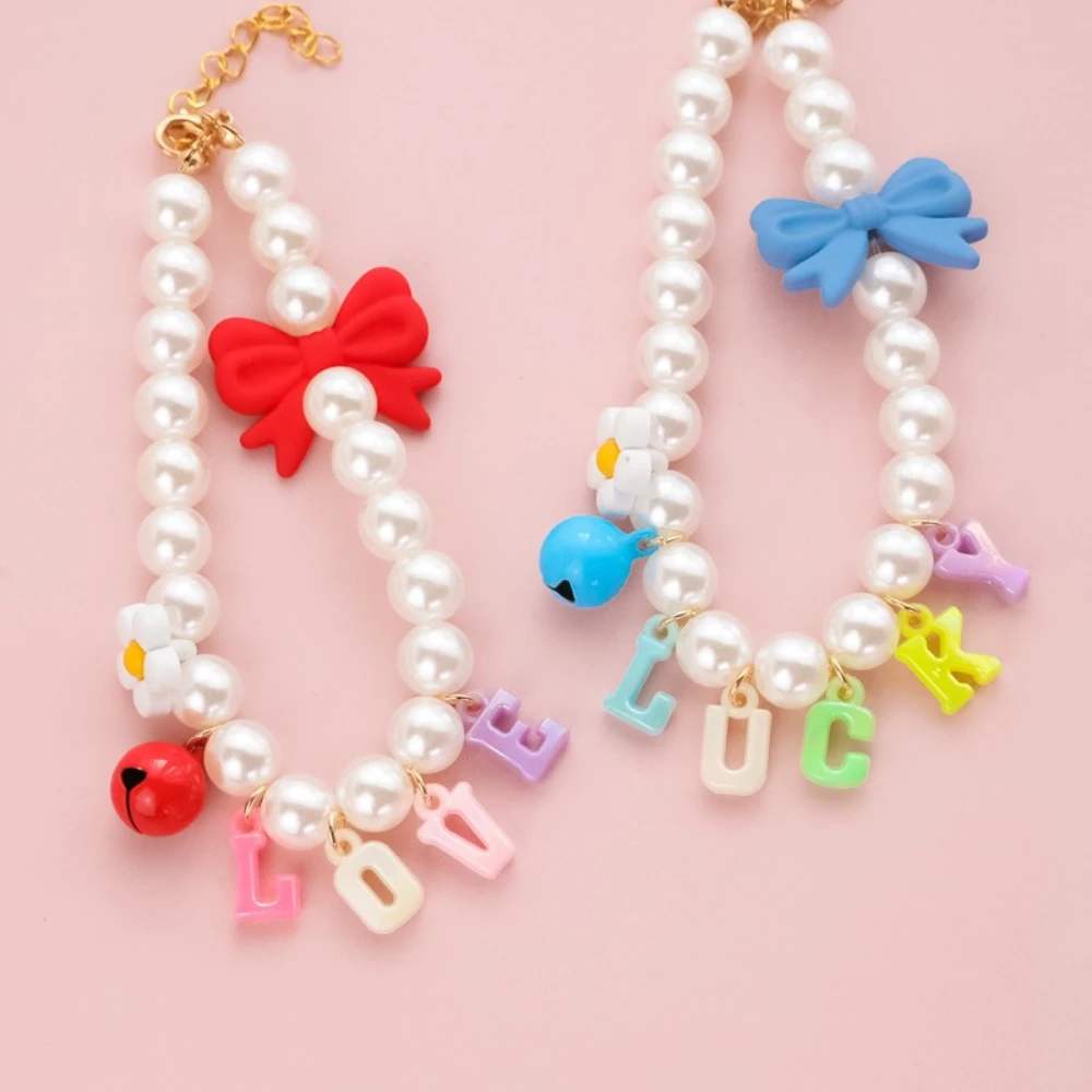 Collar rosa con perlas y campana