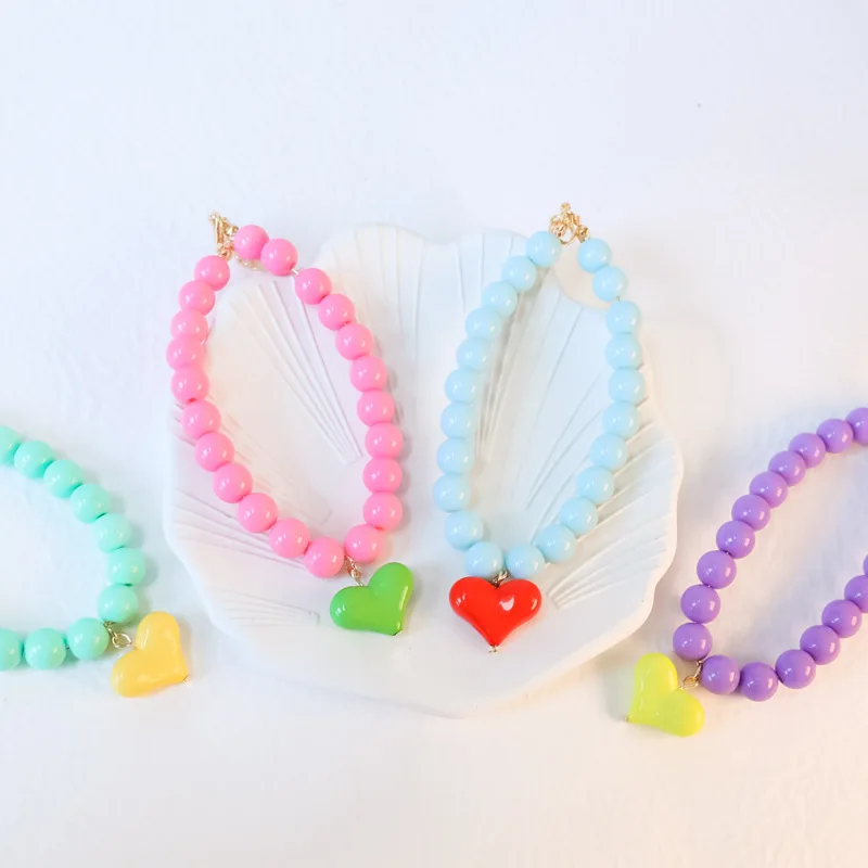Detalle del adorno de corazón y perlas del collar