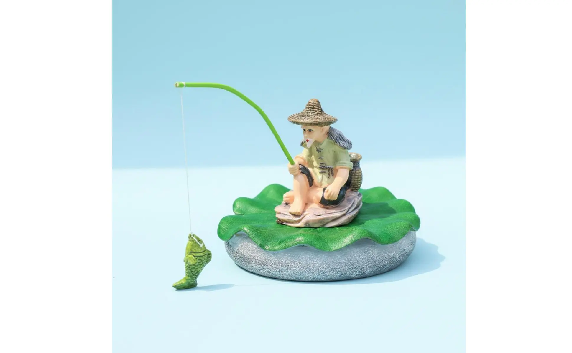 Estatua de pescador en piscina de jardín
