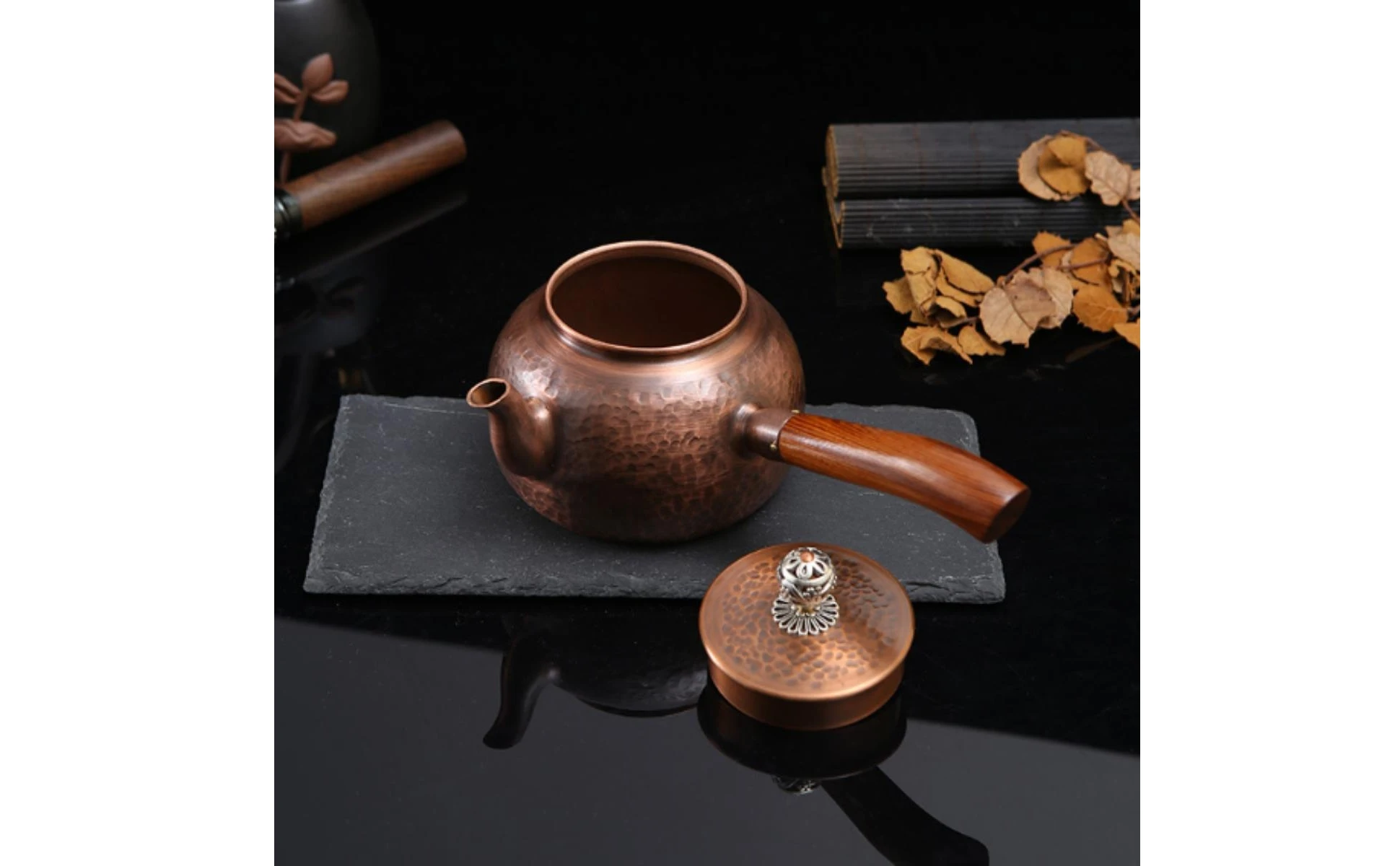 Tetera de cobre martillado con asa de madera en entorno de cocina rústica