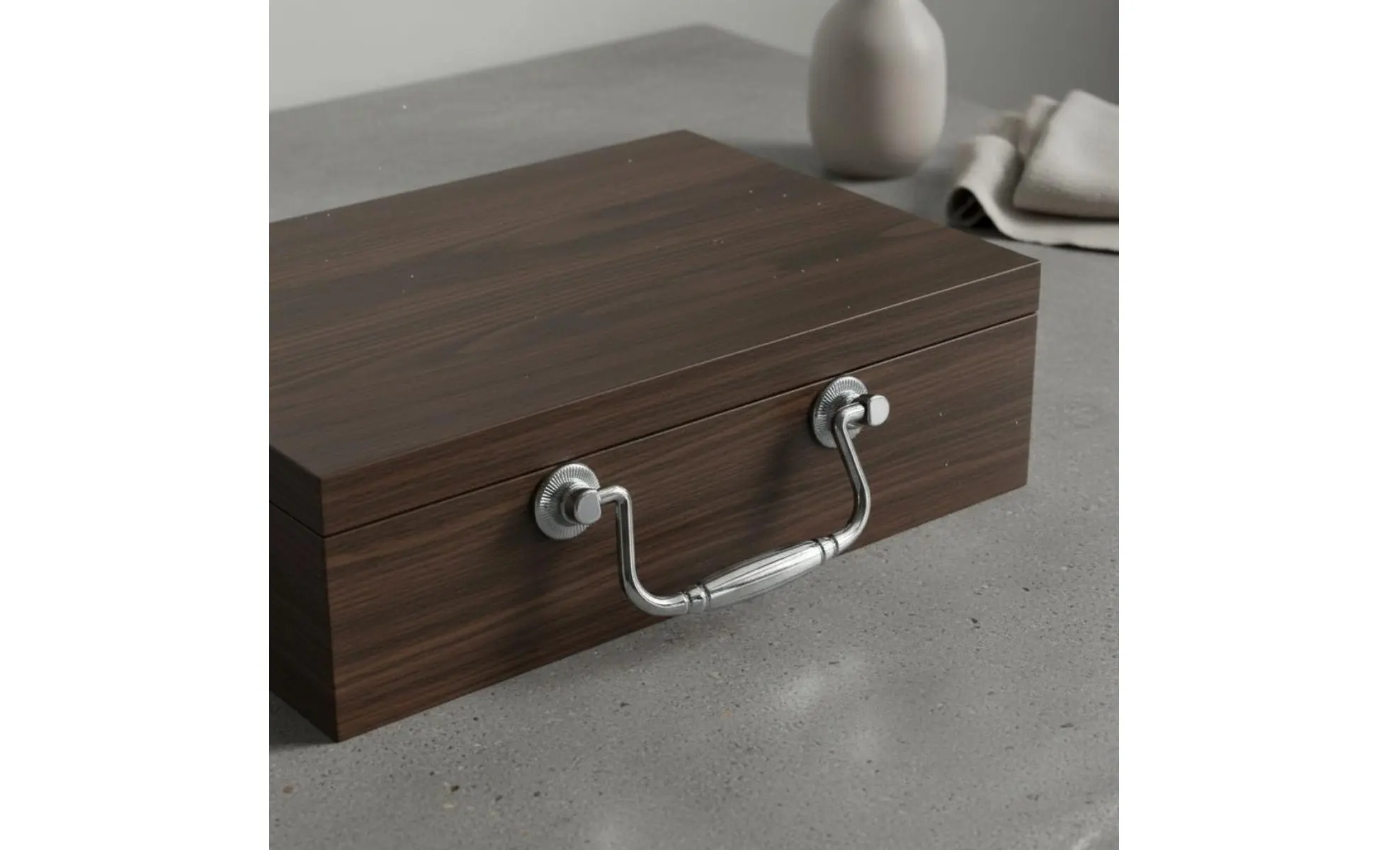 Tirador vintage con acabado pulido sobre una caja de madera
