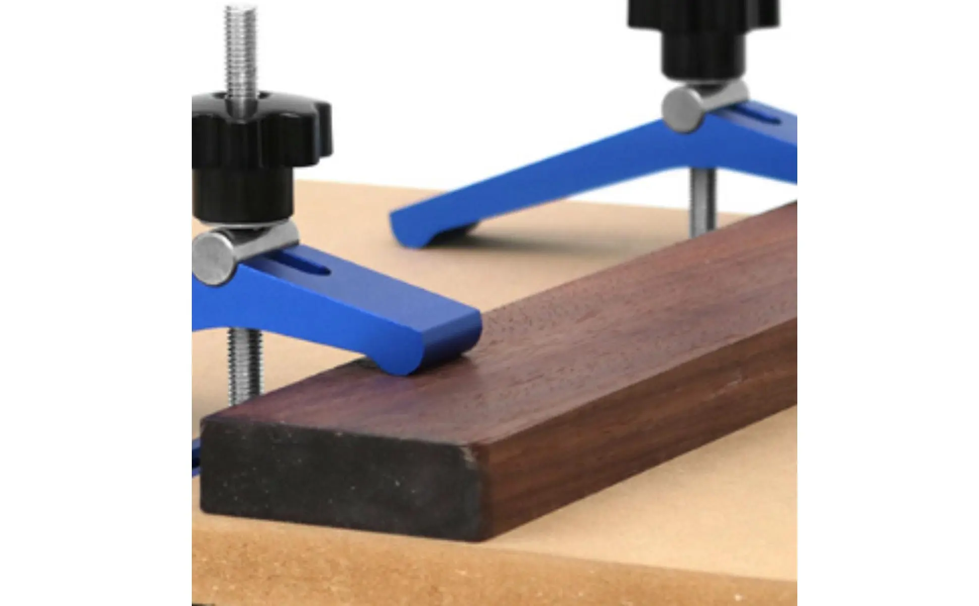 Abrazadera sujetando pieza de madera en riel guía