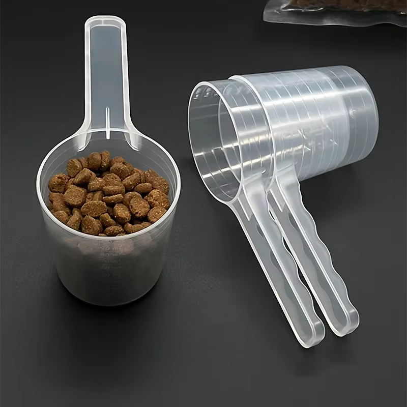Cuchara medidora transparente doblada junto a botes de suplementos