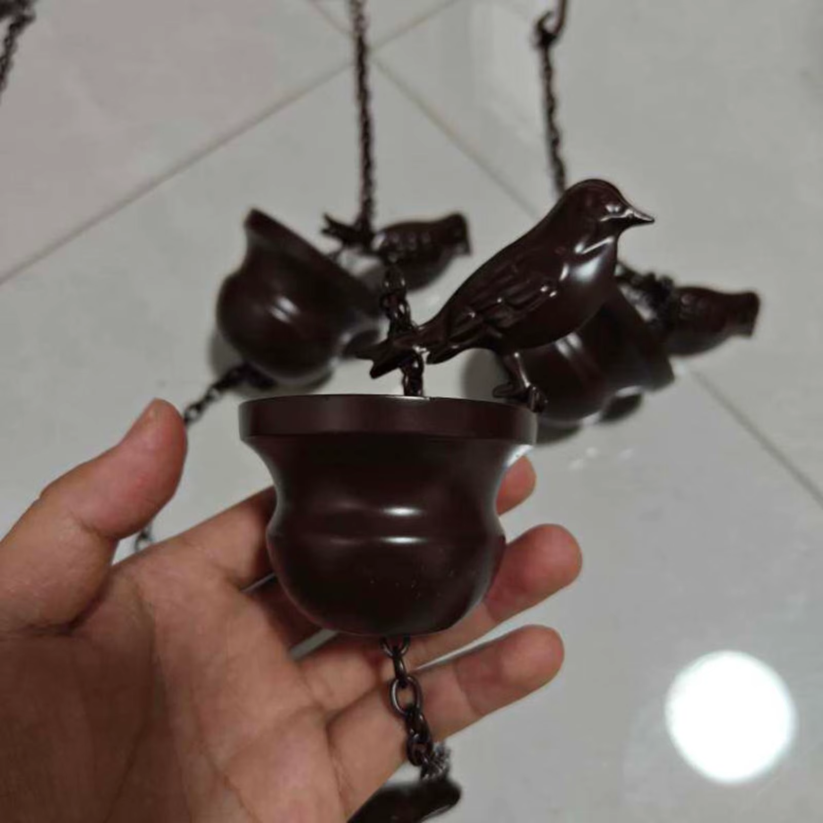 Cadena de lluvia instalada sobre un jardín con fondo verde