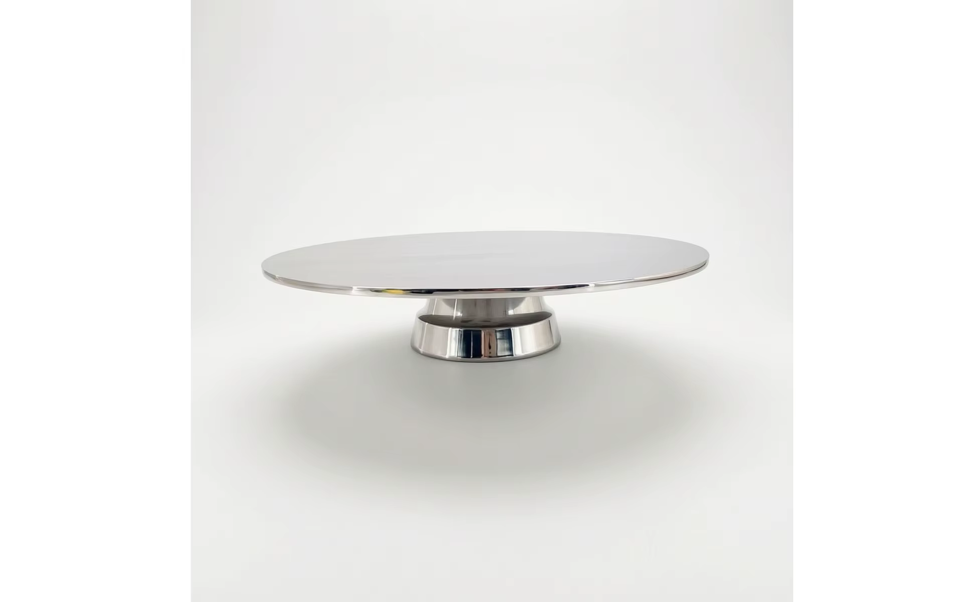 Bandeja de servicio con pedestal pulido a espejo sobre una mesa