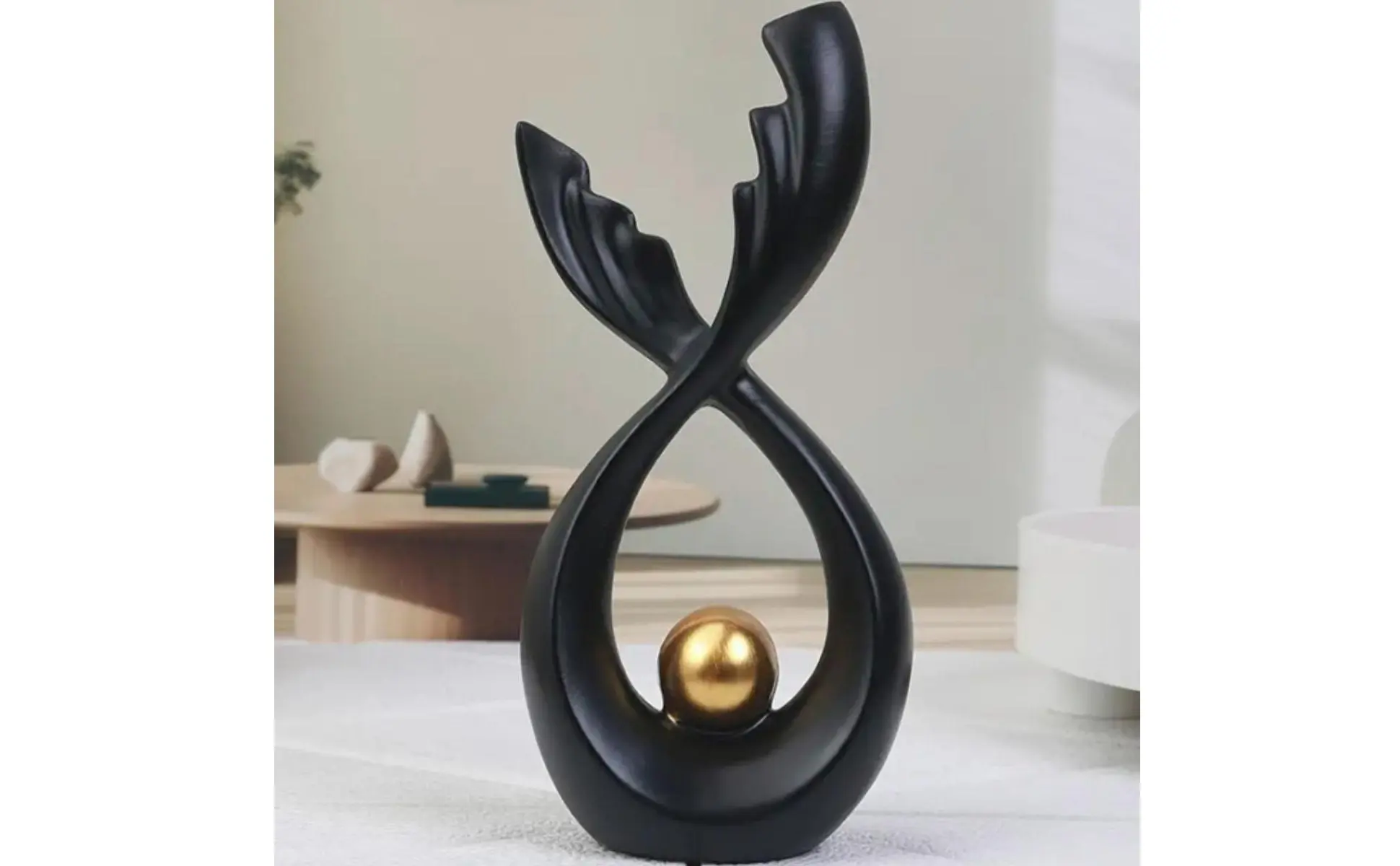 Estatua de cola de pez con esfera dorada en diseño de bucle infinito