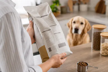 Tutora revisando la etiqueta nutricional de un pienso para perros