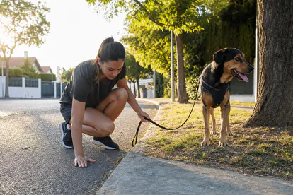 Persona comprueba con la mano la temperatura del asfalto antes del paseo