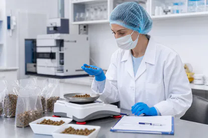 Técnica revisando muestras de alimento animal en un laboratorio de control de calidad.
